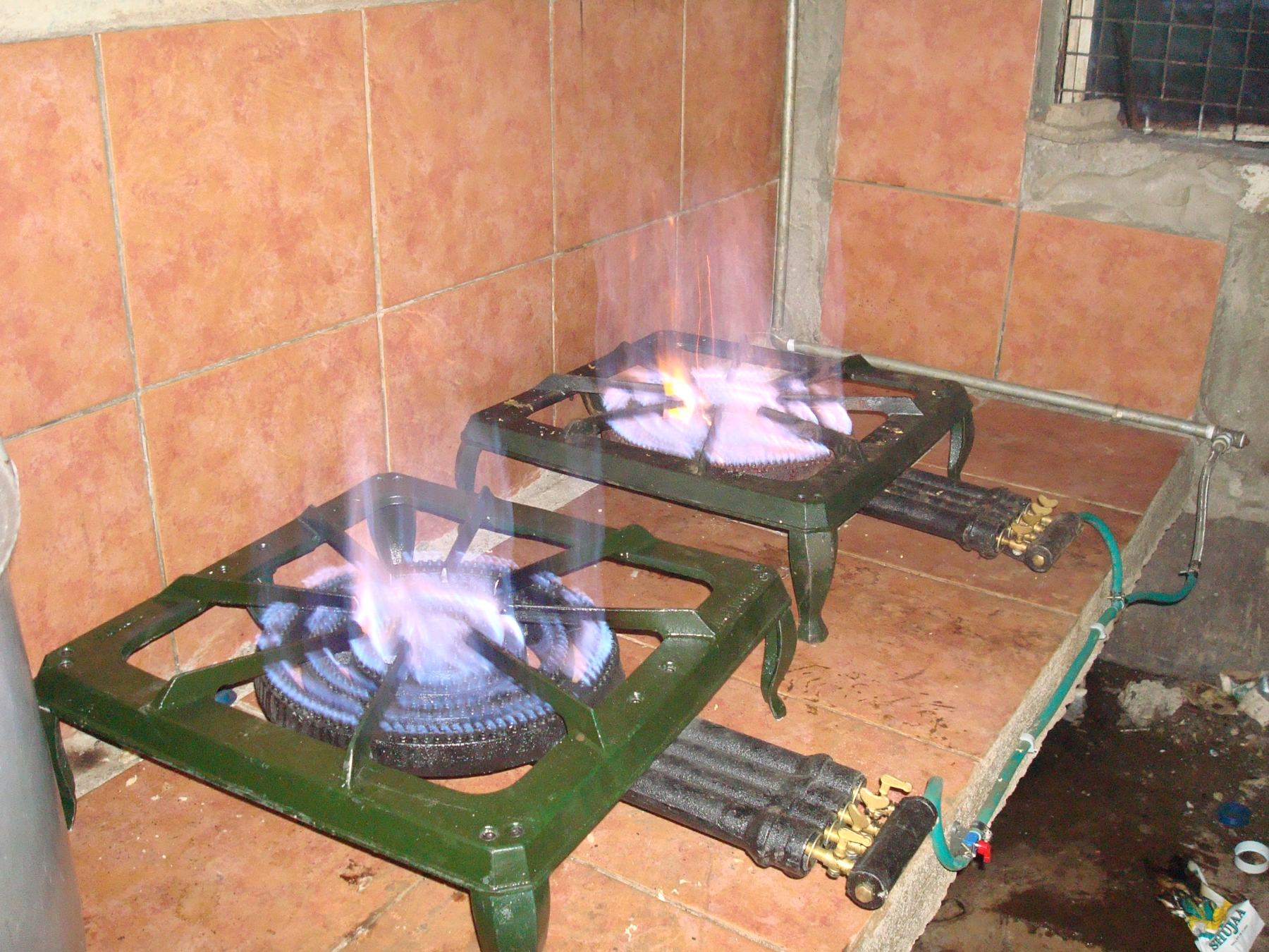 Clean-fuel burners lit with blue flames in a Kenyan school kitchen