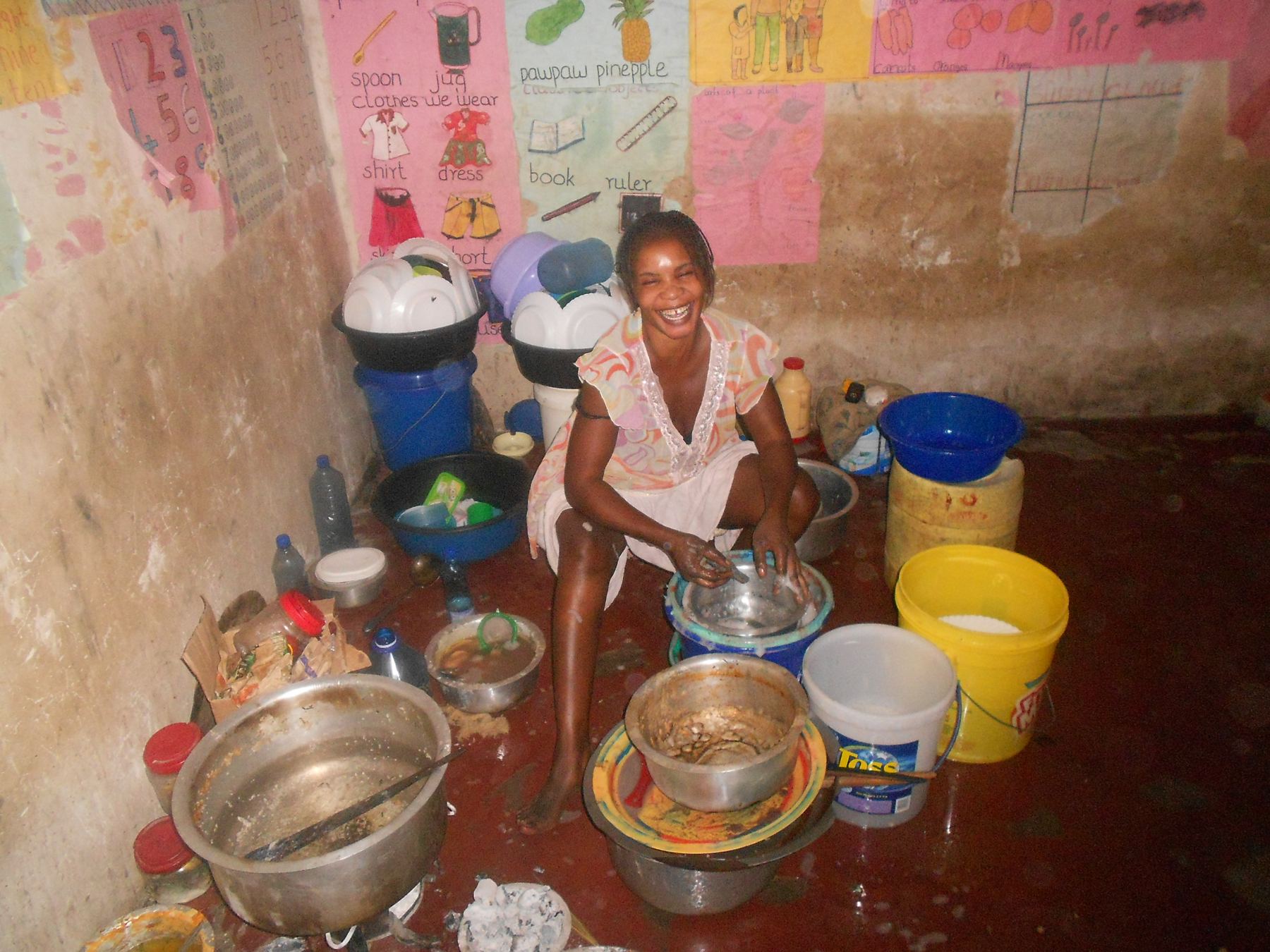 A cook at work among large pots in a kitchen in Likoni, Mombasa