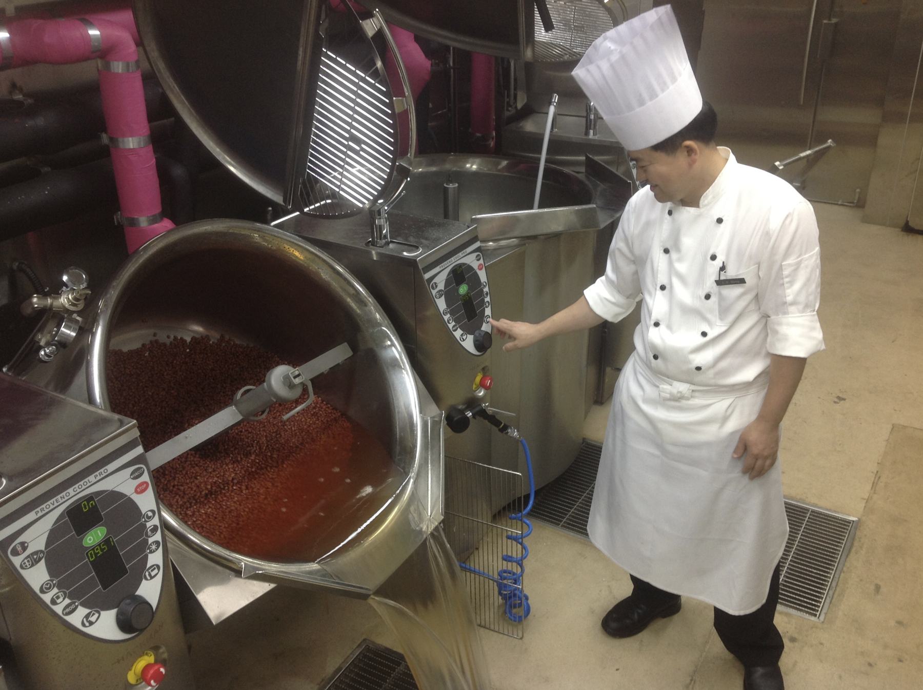 A chef cooking in a large steam-jacketed kettle